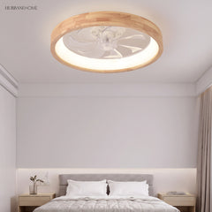 Wood ceiling fan light glowing warmly above a grey upholstered bed