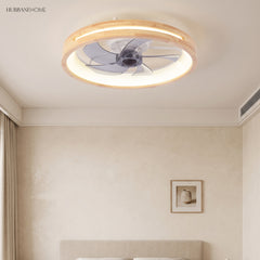 Round ceiling fan with light above a bed near a framed print