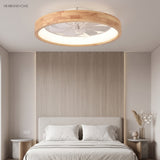 Wood rimmed ceiling fan light above a bed against a timber wall