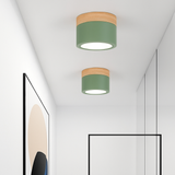 Two green ceiling lights lit on a white hallway ceiling