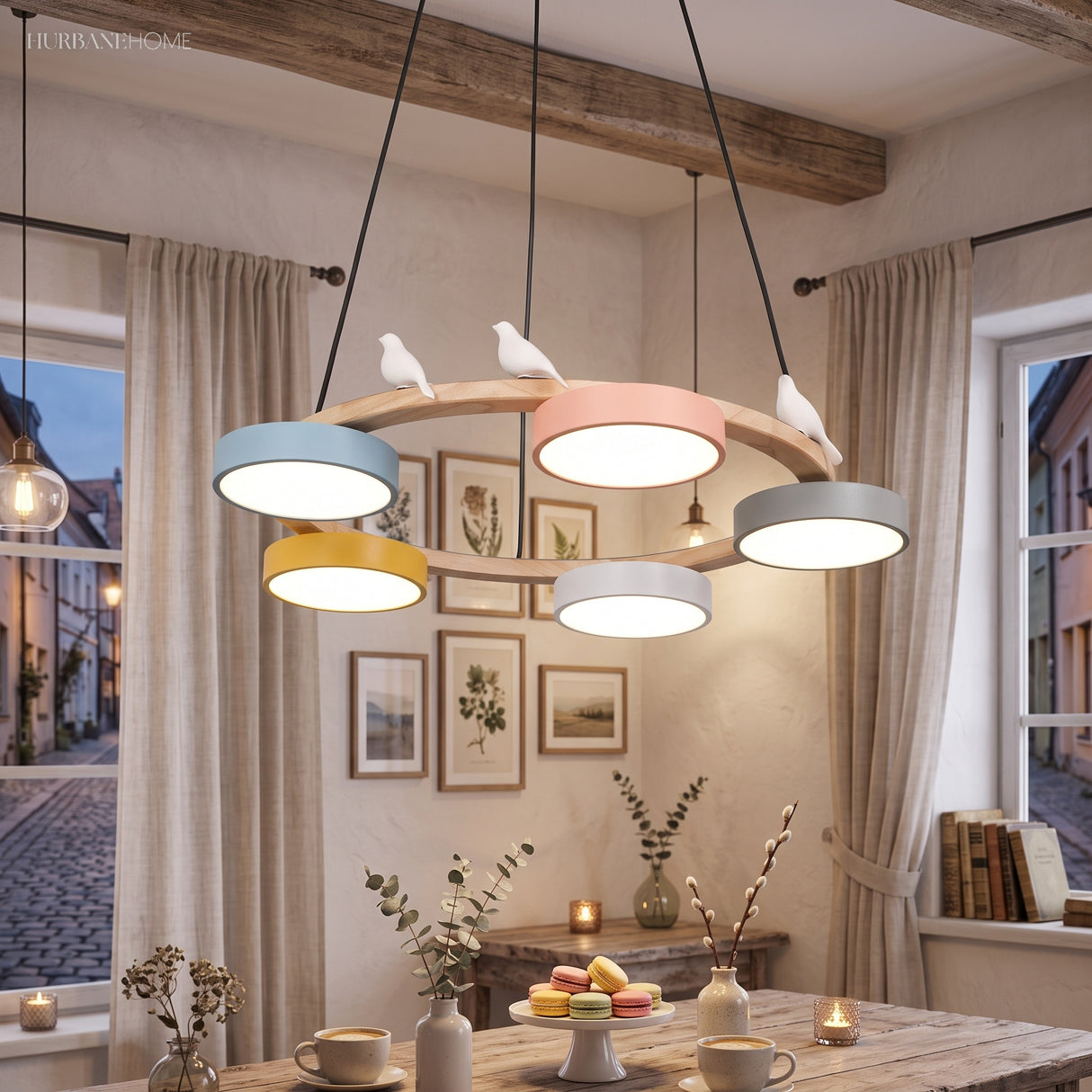 Wood round chandelier with two bird figures over a dining table with macarons