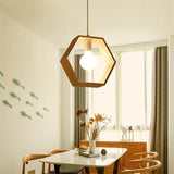 Hexagon wood pendant lit above a dining table set with flowers