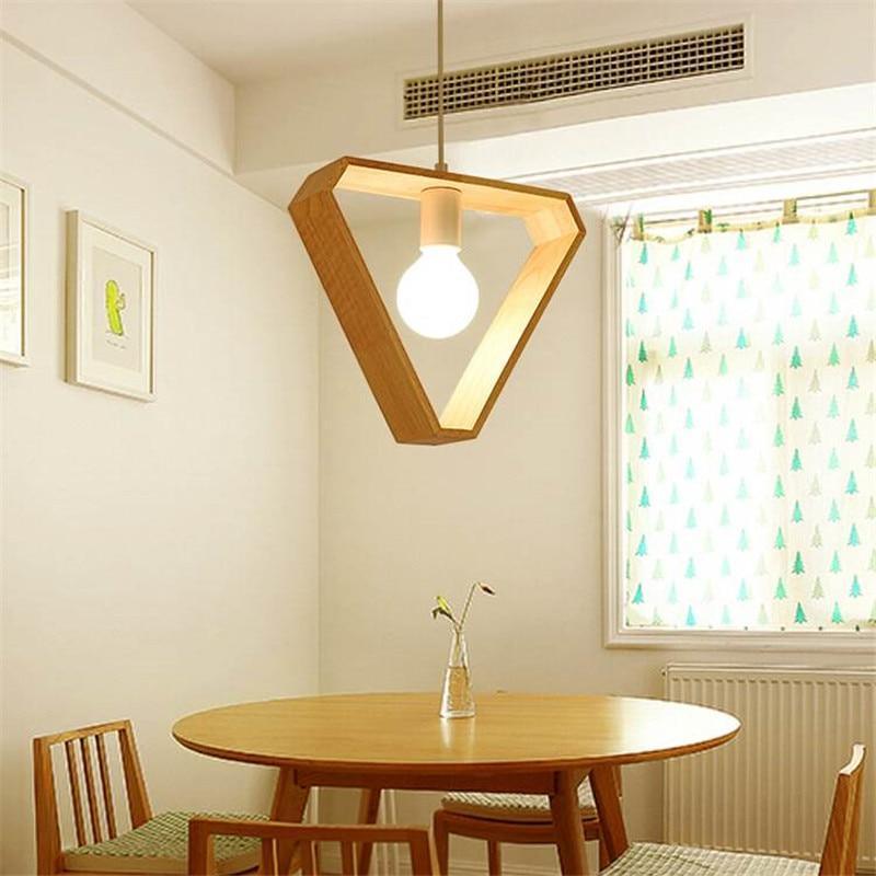Triangle wood pendant lit above a round dining table by a window