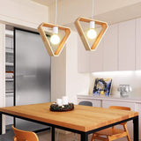Hexagon and triangle wood pendant lights hanging over a kitchen table