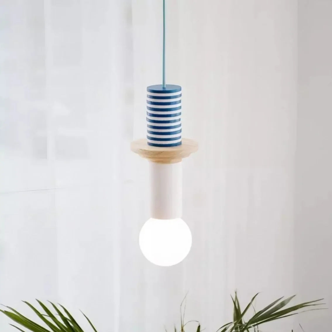 Multicolor hanging lamp with wood shapes framed by neutral wall decor