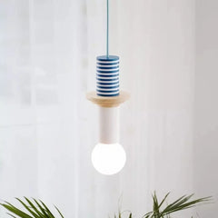 Multicolor hanging lamp with wood shapes framed by neutral wall decor