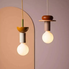 Wood pendant light with stacked painted shapes styled in a modern room scene