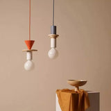 Geometric pendant light hanging above a table in a warm contemporary setting