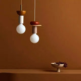 Modern globe pendant light with wood detailing over a styled interior corner