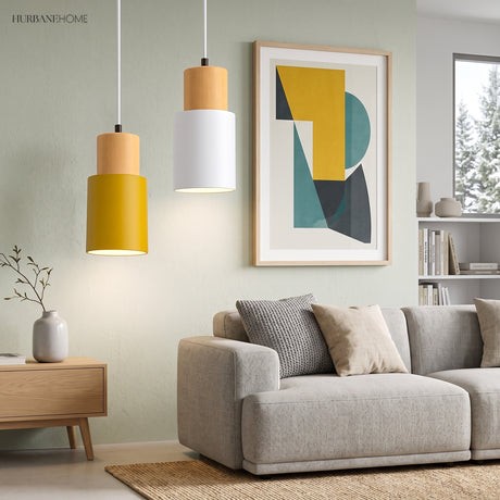 Yellow and white cylinder pendants lit above a sofa and artwork