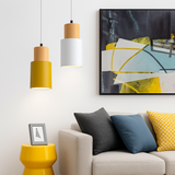 Yellow and white pendants hanging above a sofa and yellow side table
