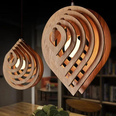 Two layered wood pendants glowing in a dark timber room