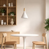 White tapered pendant with a wood top above a round table in a dining nook
