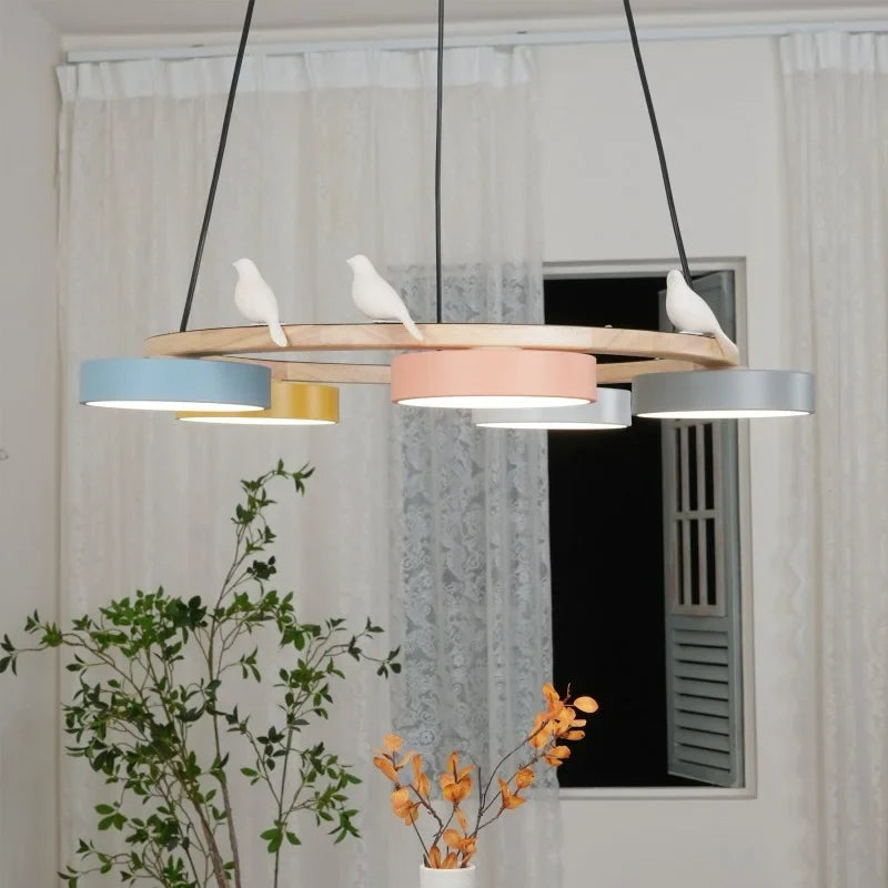 Close detail of macaron coloured drum shades mounted on the wooden chandelier ring