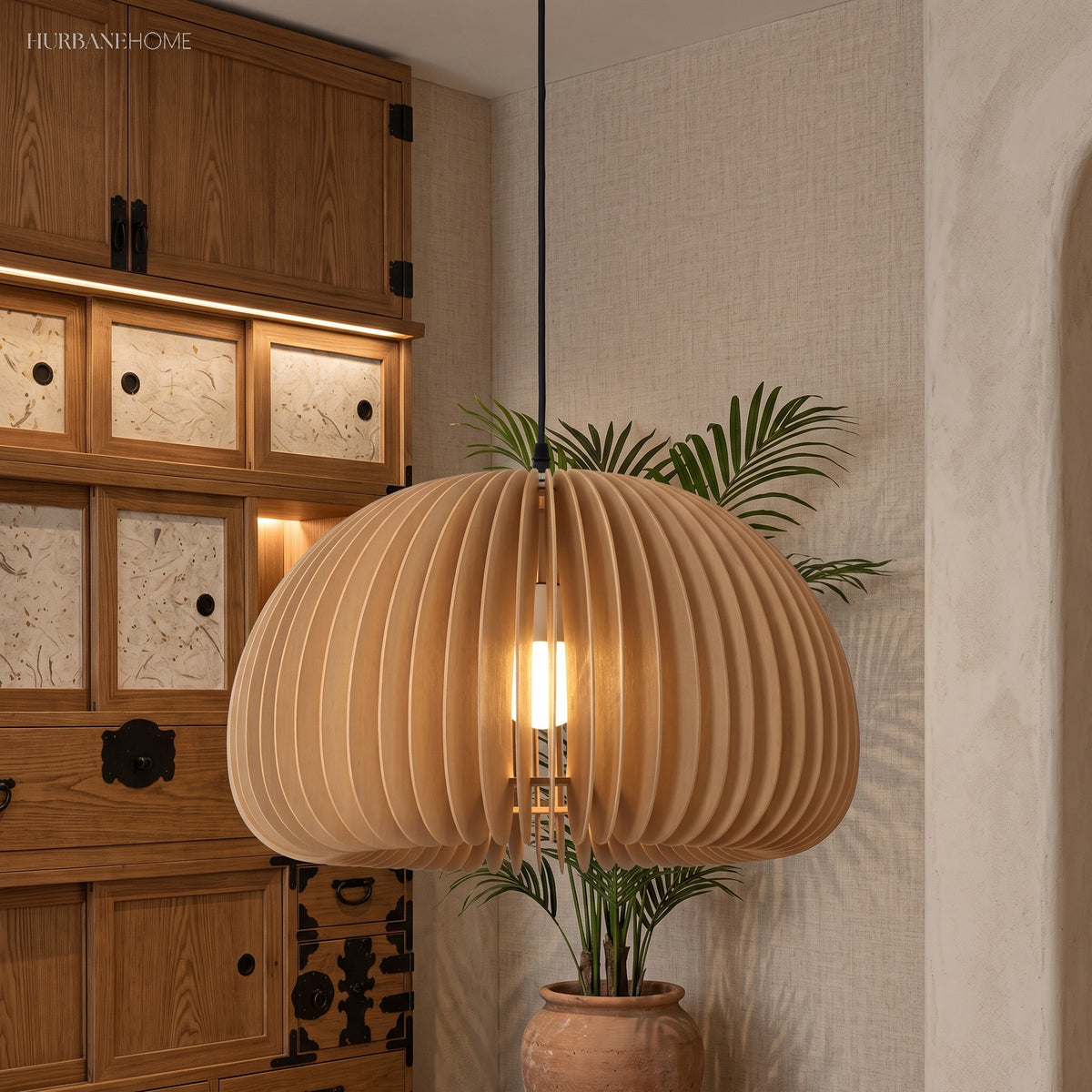 Wood dome pendant glowing beside a dark wooden cabinet and palm