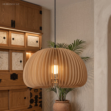 Wood dome pendant glowing beside a dark wooden cabinet and palm
