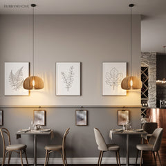 Two wood dome pendants above cafe tables beneath framed botanical prints