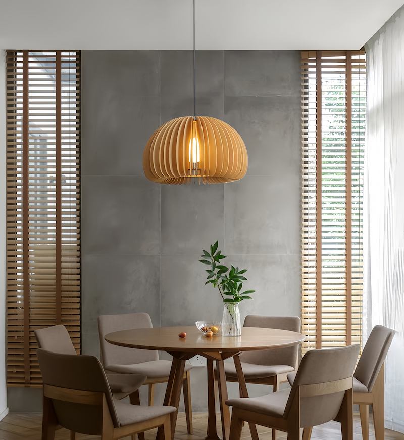 Wood slat pendant above a round dining table beside window blinds