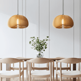 Two wood dome pendants above a pale wood dining table and chairs