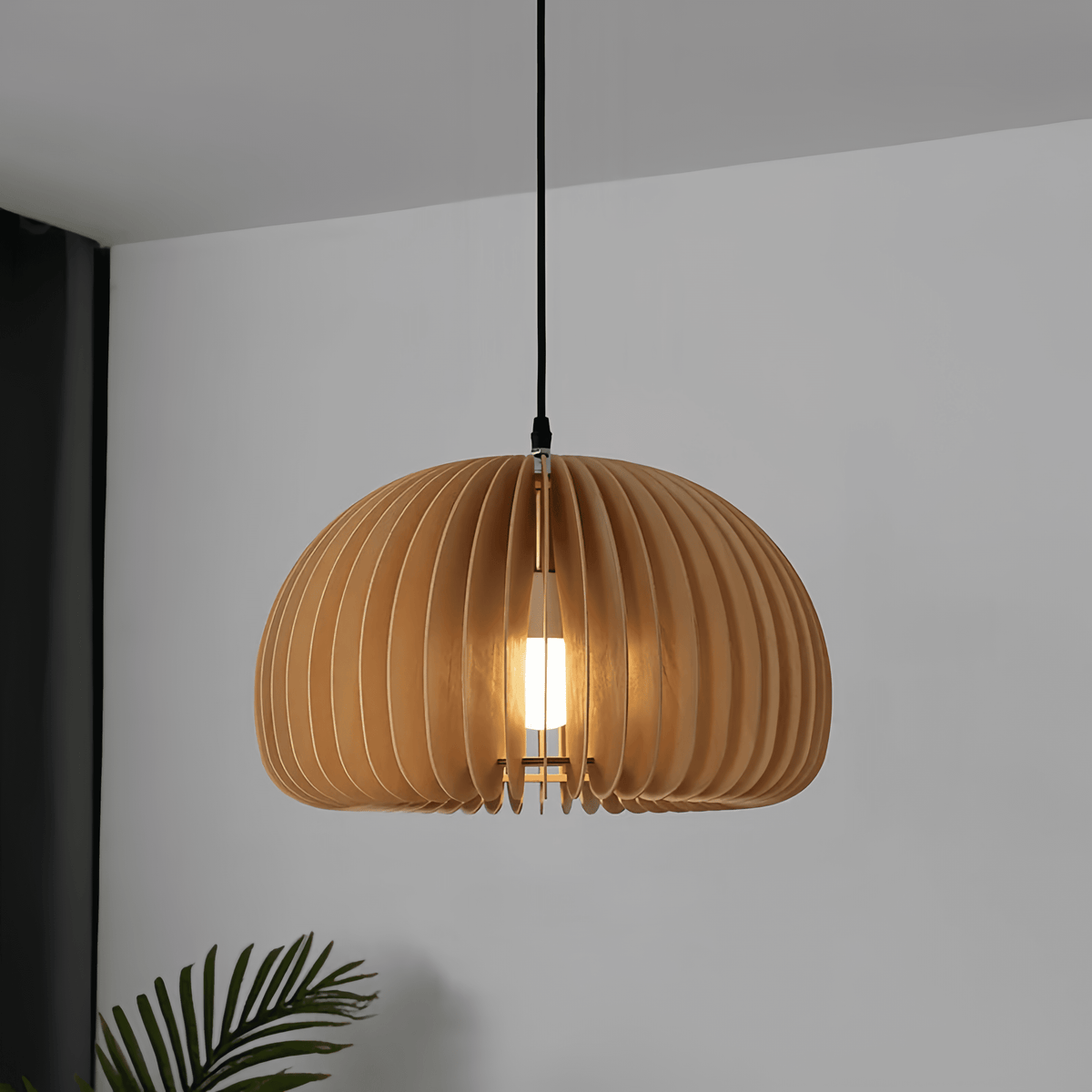 Wood slat dome pendant lit against a plain white wall