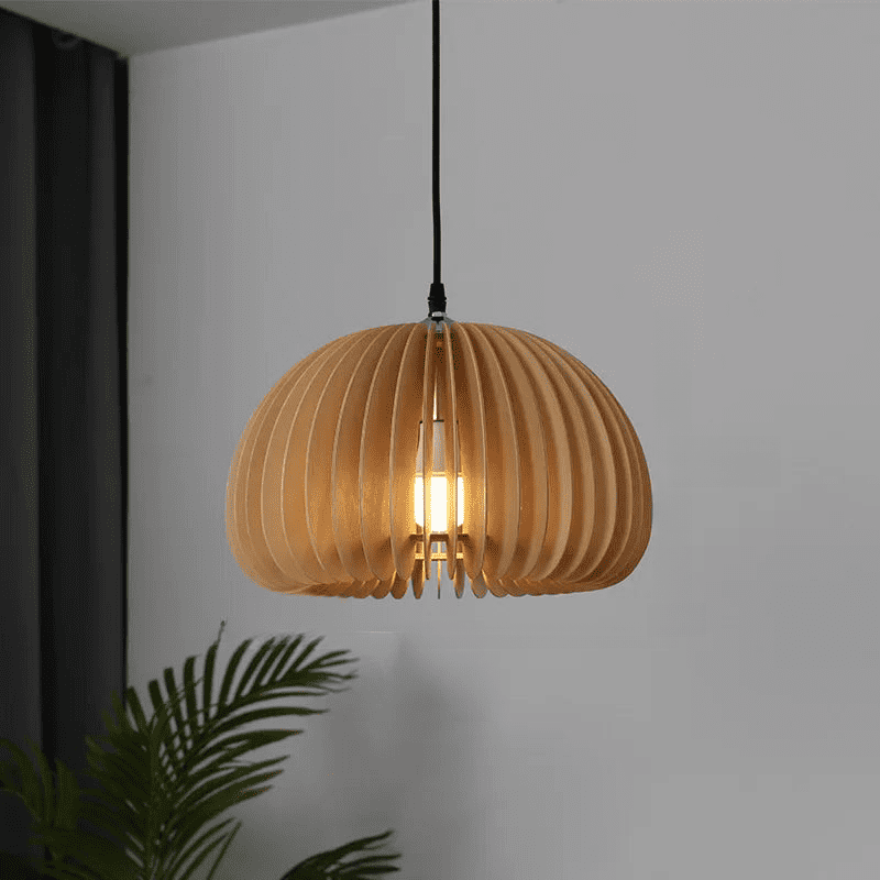 Unlit wood slat dome pendant hanging against a plain white wall