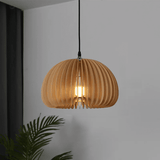 Unlit wood slat dome pendant hanging against a plain white wall