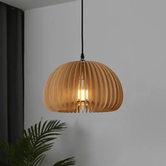 Unlit wood slat dome pendant hanging against a plain white wall