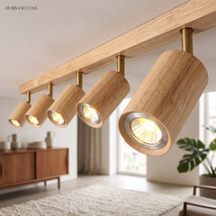 Close view of cylindrical wood spotlight heads angled along the track bar
