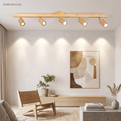 Oak track light bar over a living room with framed art and armchair