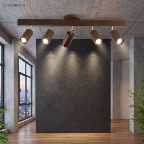 Walnut track lighting bar lighting a dark feature wall in a loft