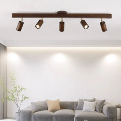 Walnut track bar lighting a white living room above a grey sofa