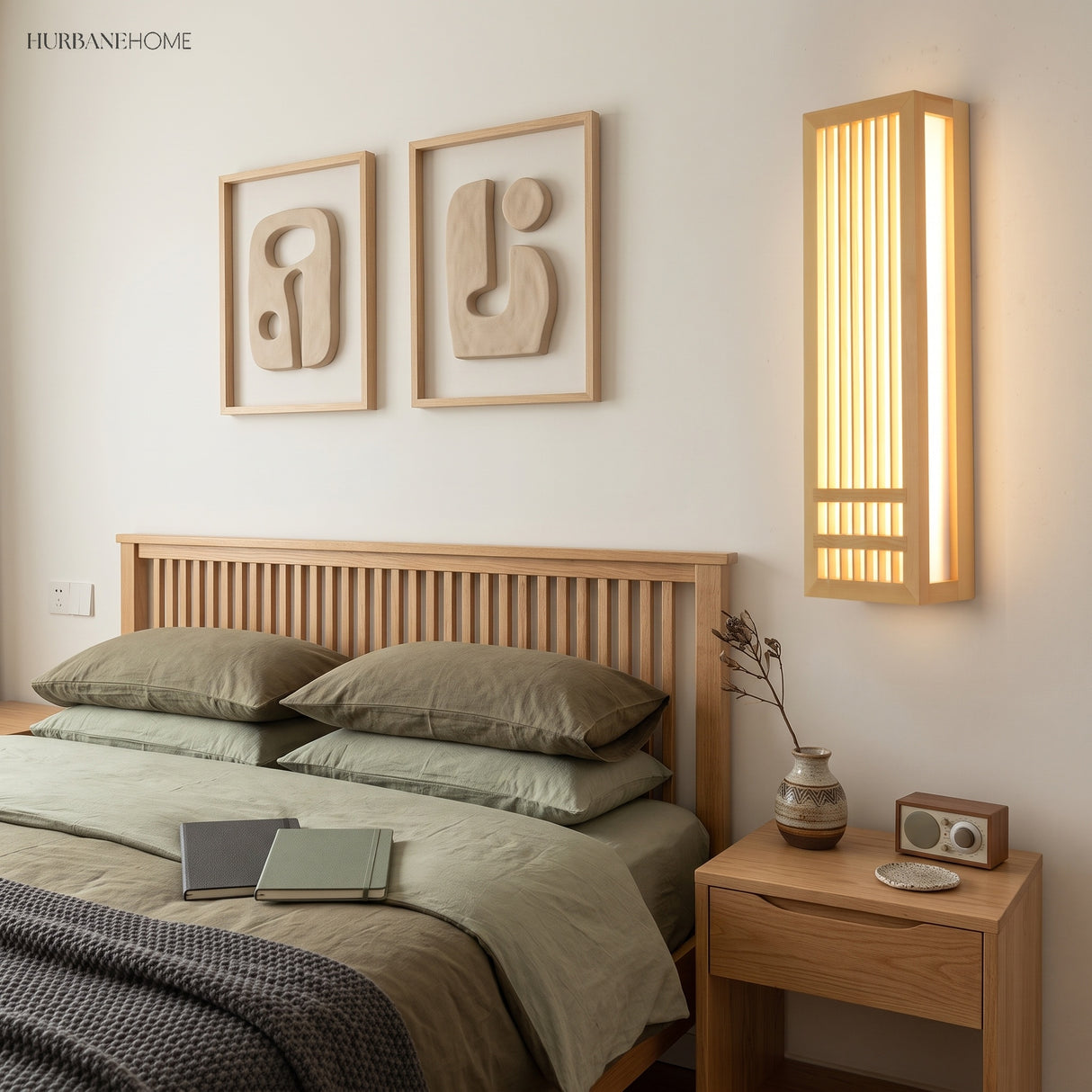 Natural wood wall sconce lighting a bedroom beside framed art and a nightstand