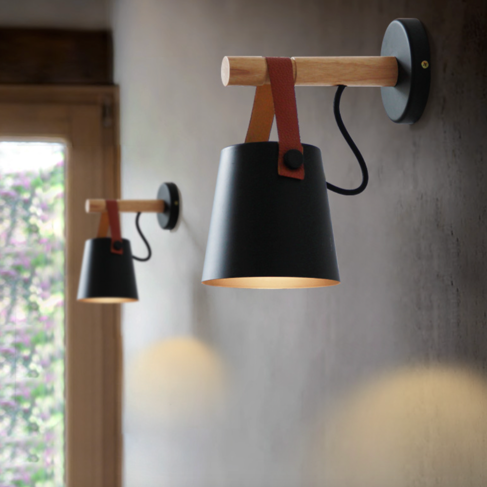 Two black sconces lit on a concrete wall beside a window