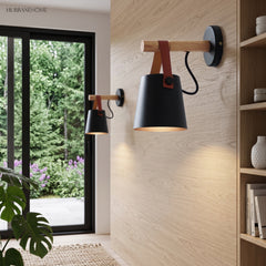 Black sconce lit on oak panelling beside a garden door
