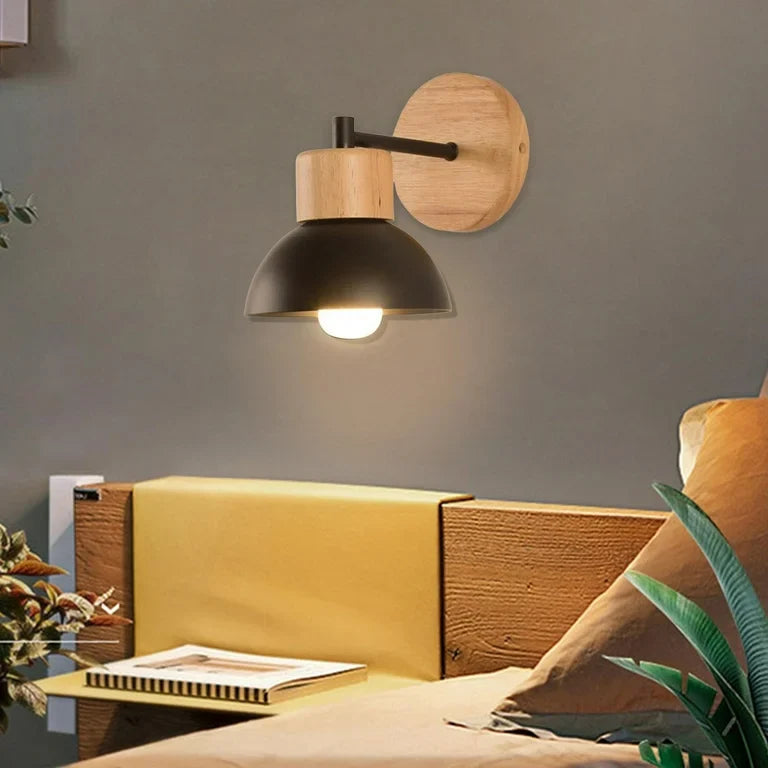 Wood sconce with a black dome lit above a yellow headboard