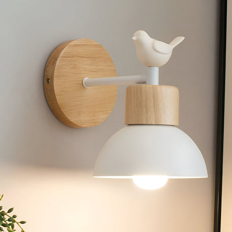 White domed wood sconce with a bird figure beside a framed print