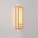 Tall wood wall sconce lit at an angle with warm light on the wall