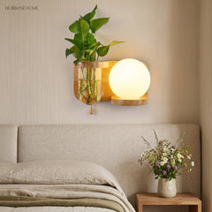 Wood planter sconce lit above a bed with a linen throw