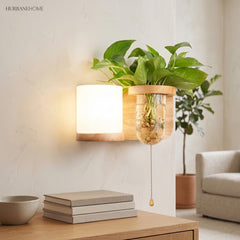 Wood planter sconce lit above a stack of books and a bowl