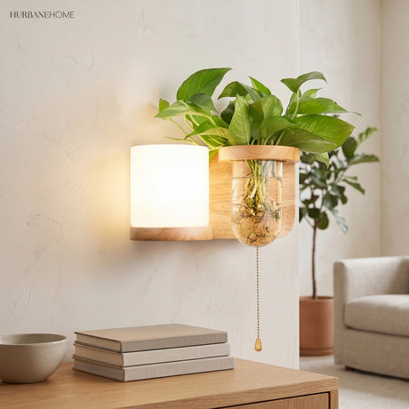Wood planter sconce lit above a stack of books and a bowl
