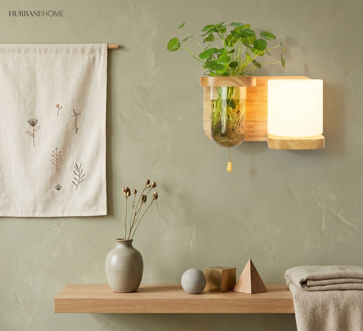 Wood sconce with a cylinder shade and a leafy plant vase