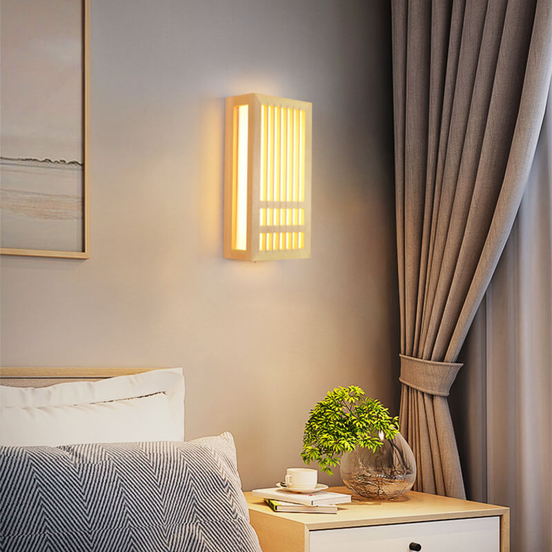 Small and large natural wood wall sconces lit together on a warm wall