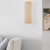 Tall unlit wood wall sconce on a living room wall beside framed artwork