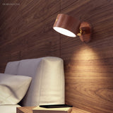 Walnut cordless wall sconce glowing above a bed headboard at night