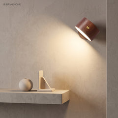 Walnut rechargeable wall sconce lighting a shelf with a warm downward glow