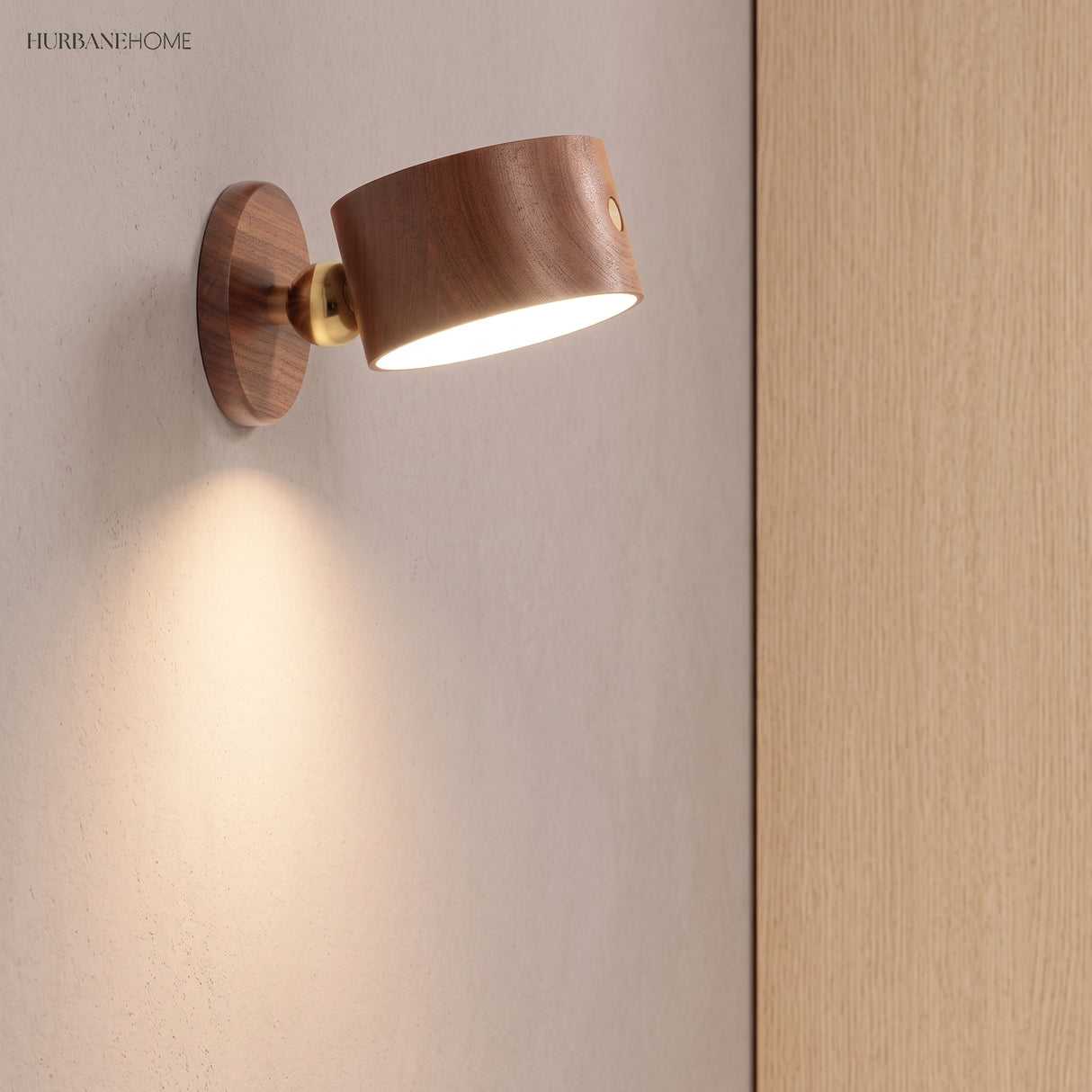 Walnut LED wall sconce tilted on a brass joint beside a wooden door
