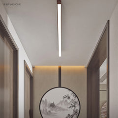 Wood grain LED flush mount bar light glowing in a narrow hallway