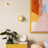 Yellow orb wall sconce angled view with the glass globe catching light