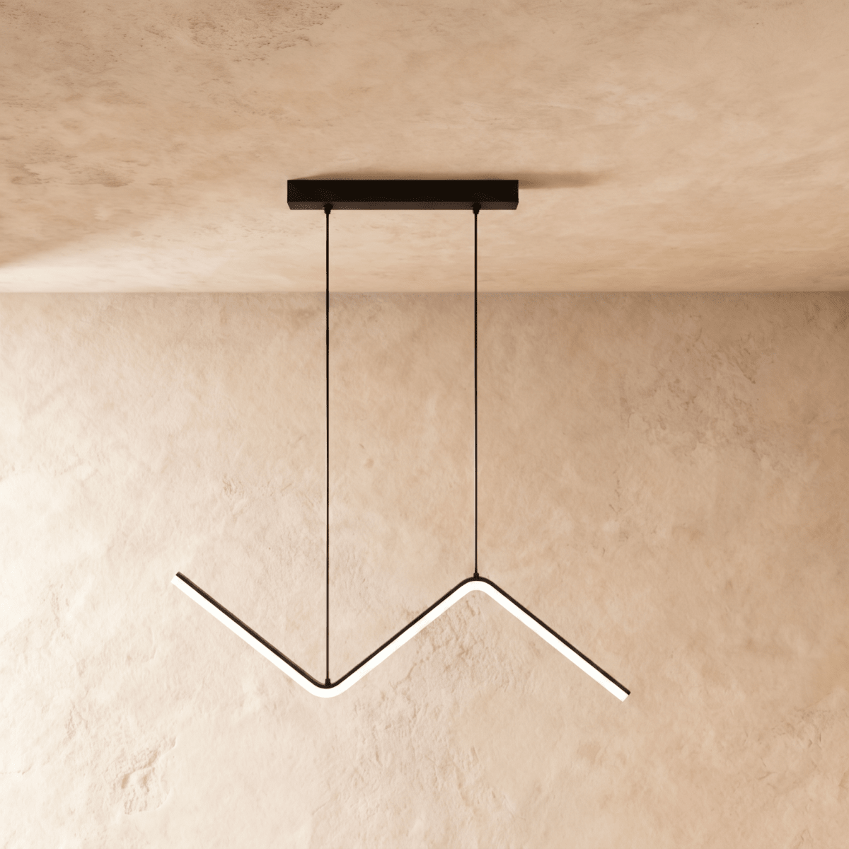 Black zigzag pendant lit against a warm plaster wall from a slim ceiling plate