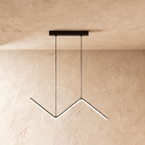 Black zigzag pendant lit against a warm plaster wall from a slim ceiling plate